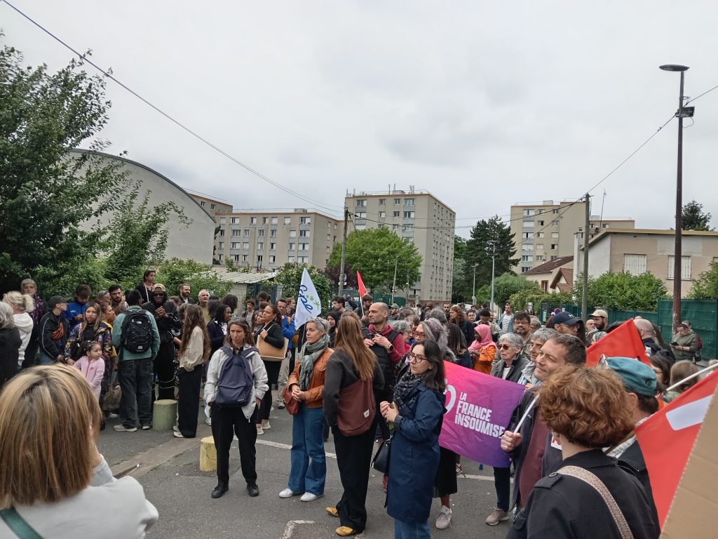 Groupe de personnes rassemblées devant l’école